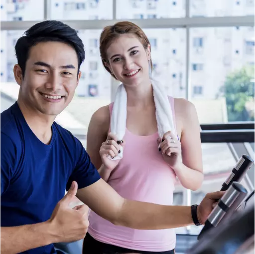 Happy couple using the gym at their condo