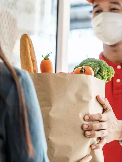 Woman receiving a grocery delivery at her doorstep